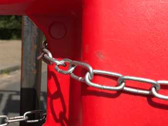 silver chain on a red bollard road block