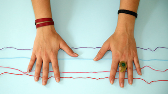 Photograph of a pair of hands making a friendship bracelet